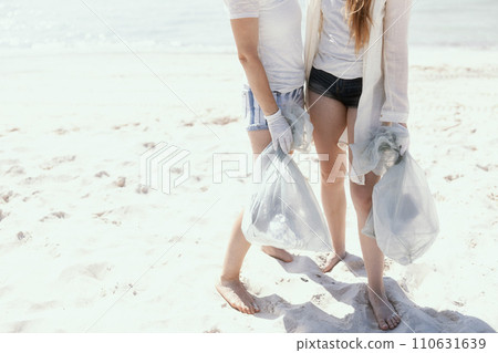 Closeup on environment activists on beach collecting waste 110631639