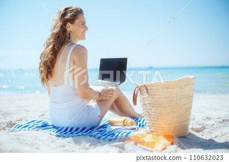 happy elegant woman on beach with straw bag happy elegant woman on beach with straw bag 110632023