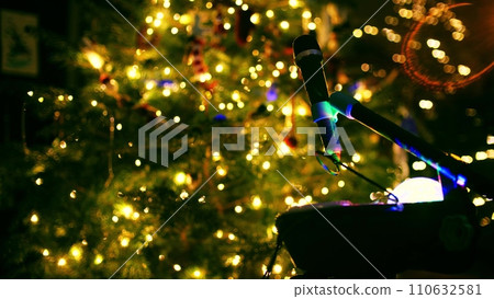 Microphone at decorated lit Christmas or New Year tree in the evening Microphone at decorated lit Christmas or New Year tree in the evening 110632581