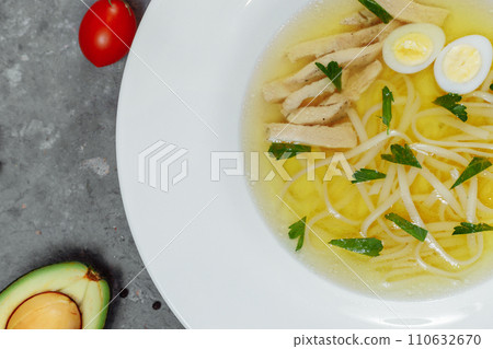 Low-fat chicken broth with a half cooked egg and parsley in a glass bowl isolated on white background. Low-fat chicken broth with a half cooked egg and parsley in a glass bowl isolated on white background. 110632670
