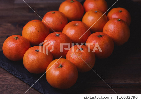 Photo of tangerines lined up in rows on the black stone board. Photo of tangerines lined up in rows on the black stone board. 110632796