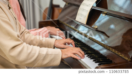 Family. Young woman teaching piano for senior man teaching, happy daughter and elderly father with eyeglasses relaxation playing piano together in living room at home, lifestyle life after retirement 110633785