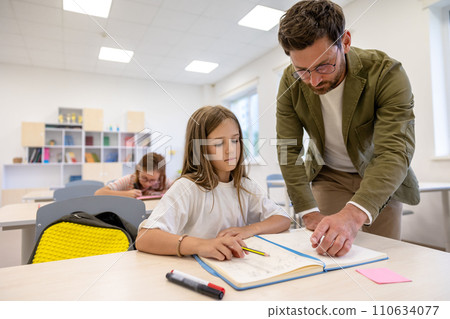 Man teacher helping pupils during lesson in school. Man teacher helping pupils during lesson in school. 110634077