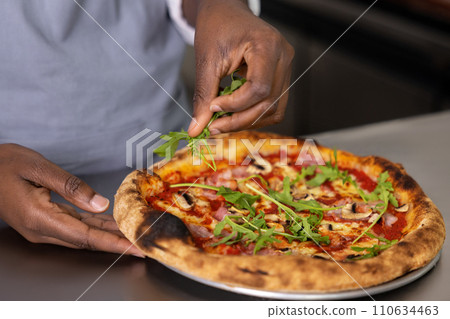 Close up picture of females hands cutting pizza 110634463