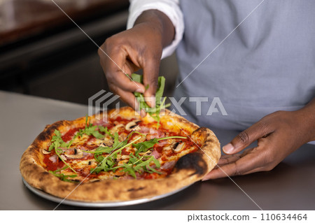 Close up picture of females hands cutting pizza 110634464