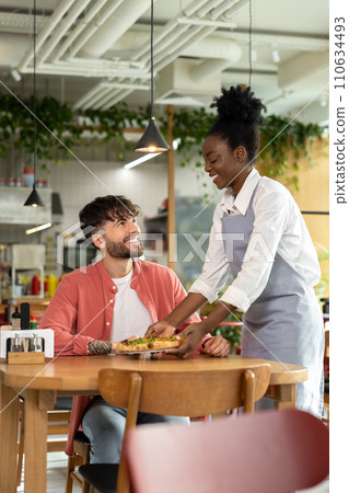 African american waitress taking order from customer in a cafe African american waitress taking order from customer in a cafe 110634493