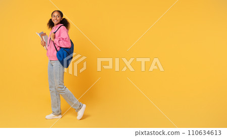 African girl student holds workbooks posing with backpack, yellow background African girl student holds workbooks posing with backpack, yellow background 110634613