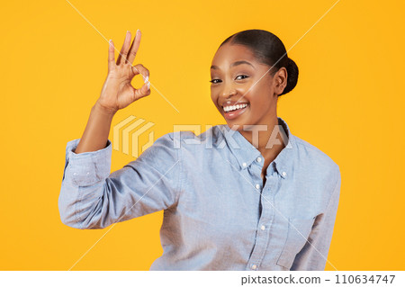 Cheerful Black Lady In Casual Gesturing Okay Symbol, Yellow Background Cheerful Black Lady In Casual Gesturing Okay Symbol, Yellow Background 110634747