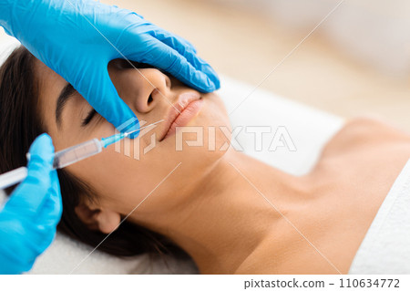 Pretty indian lady receiving hyaluronic acid injection Pretty indian lady receiving hyaluronic acid injection 110634772