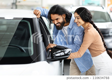 Happy Indian Spouses Looking Inside Of Their New Car Together 110634788