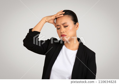 Exhausted Asian businesswoman holding her forehead in stress or headache, eyes closed 110634828