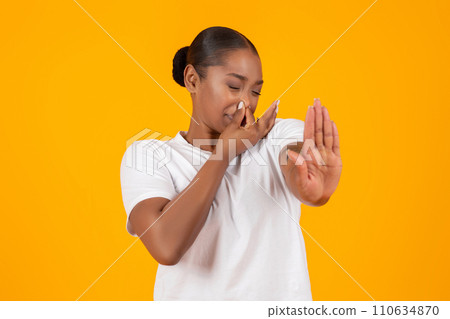 Disgusted young black lady closing nose showing STOP gesture, studio Disgusted young black lady closing nose showing STOP gesture, studio 110634870