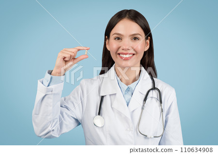 Cheerful woman doctor showing small pill, healthcare and treatment 110634908