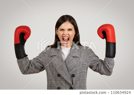 Determined woman in plaid with boxing gloves, ready to fight Determined woman in plaid with boxing gloves, ready to fight 110634924