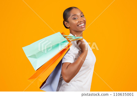 Portrait of happy black woman posing with shopper bags packages Portrait of happy black woman posing with shopper bags packages 110635001