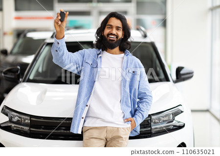 Emotional handsome eastern guy raising hand with car key 110635021