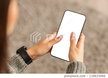Unrecognizable young lady using smartphone with white screen Unrecognizable young lady using smartphone with white screen 110635066