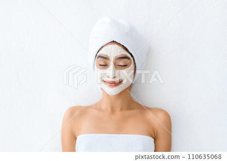 Top view indian woman applying facial clay mask at spa 110635068