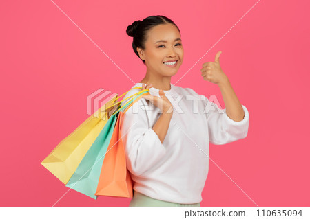 Great Shopping. Happy asian lady holding shopper bags and showing thumb up 110635094