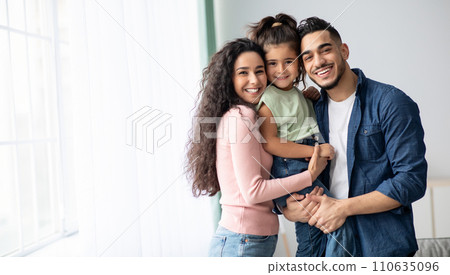 Portraif Of Happy Arabic Parents Posing With Their Little Daughter At Home 110635096