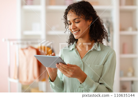 Focused latin woman with tablet in light-filled design studio 110635144