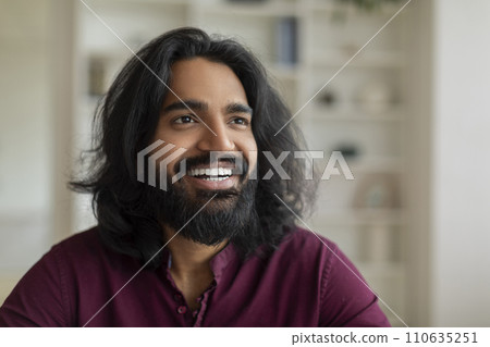 Portrait of handsome young indian male looking aside and smiling 110635251