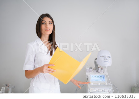 Smiling woman cosmetologist with medical report in Smiling woman cosmetologist with medical report in 110635333