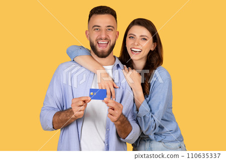 Laughing couple holding credit card, ready for joyful purchase Laughing couple holding credit card, ready for joyful purchase 110635337