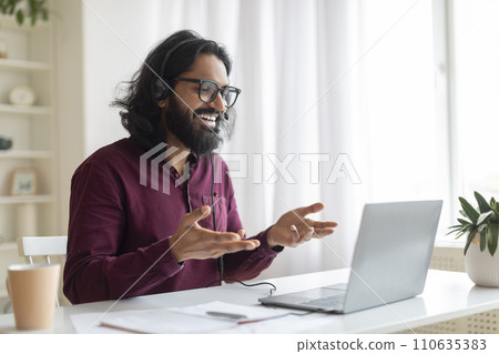 Online Tutoring. Young indian tutor wearing headset making video call on laptop 110635383