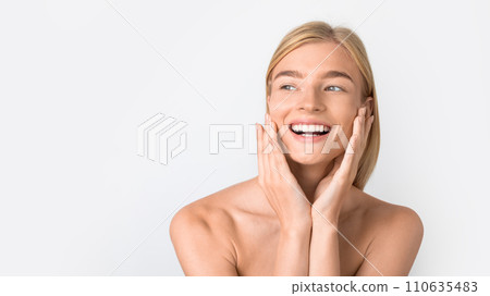 Attractive happy caucasian lady touching her face against white backdrop 110635483