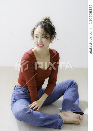 Portrait of a young woman in red clothes, vertical position 110636325