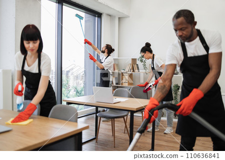 People of cleaning service cleans tables, floor, and panoramic windows. People of cleaning service cleans tables, floor, and panoramic windows. 110636841