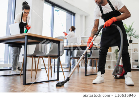 Cropped view of hands of African man holding vacuum cleaner. 110636940