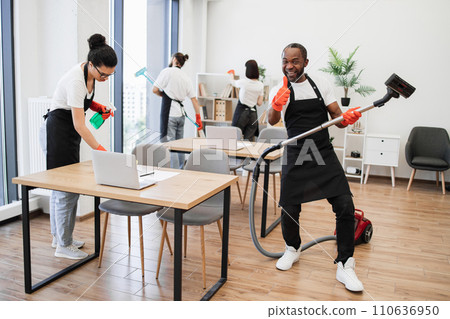 African man having fun holding vacuum cleaner like guitar at concert. African man having fun holding vacuum cleaner like guitar at concert. 110636950