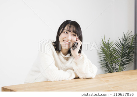 A young woman talking on a smartphone 110637056