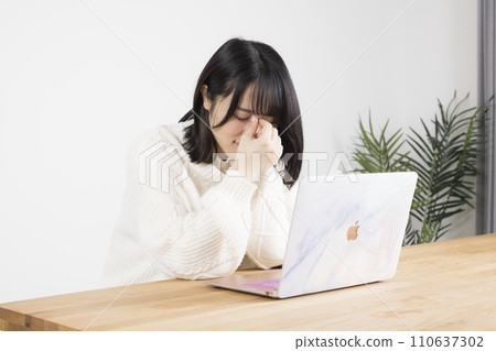 一位女士在操作智慧型手機時眼睛感到疲勞 110637302