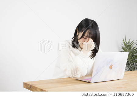 A woman whose eyes get tired while operating a smartphone A woman whose eyes get tired while operating a smartphone 110637360