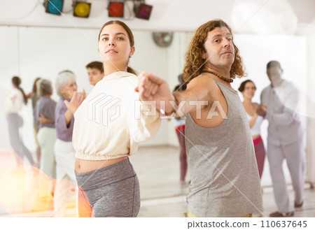 Happy caucasian guy and girl practising paired latin dance in dance studio 110637645