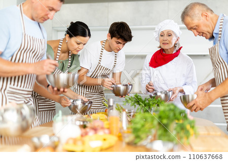 Elderly woman professional chef conducting group culinary courses 110637668