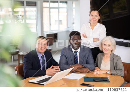 Group of different people posing at table in office Group of different people posing at table in office 110637821