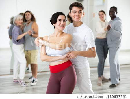 Caucasian man and lady rehearsing latin paired dance moves 110637861
