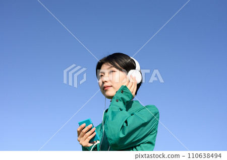 woman listening to music outdoors 110638494