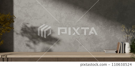 Empty copy space on a wooden tabletop against the cement loft wall with shadow and daylight indoors. 110638524