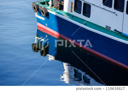 Light hitting the stern of the port ferry and reflection on the water surface Light hitting the stern of the port ferry and reflection on the water surface 110638827