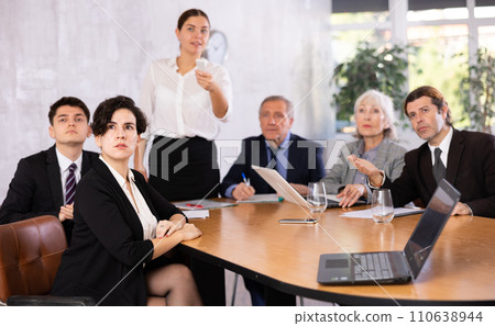 Young Hispanic businesswoman listening to presentation of partners Young Hispanic businesswoman listening to presentation of partners 110638944