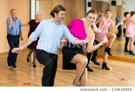 Happy couple performing a paired dance in ballroom Happy couple performing a paired dance in ballroom 110638988