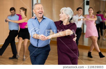 Elderly amateur couple practicing vigorous lindy hop in studio 110639003