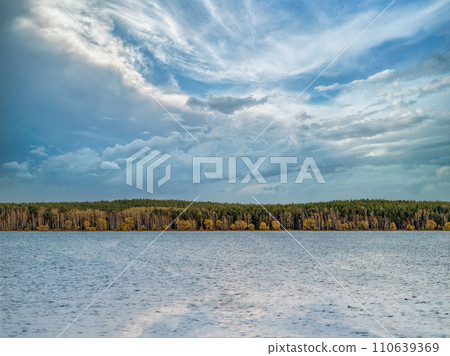 Lake with pine and birch forest on the shores at summer or early autumn sunset. Lake with pine and birch forest on the shores at summer or early autumn sunset. 110639369