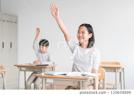 Smiling elementary school students raising their hands during class in school classrooms/cram schools (summer classes, raising hands, studying, after-school children, children's clubs, after-school childcare) Smiling elementary school students raising their hands during class in school classrooms/cram schools (summer classes, raising hands, studying, after-school children, children's clubs, after-school childcare) 110639899