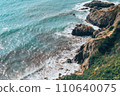 Large waves crash on the rocky shore view from above.  110640075